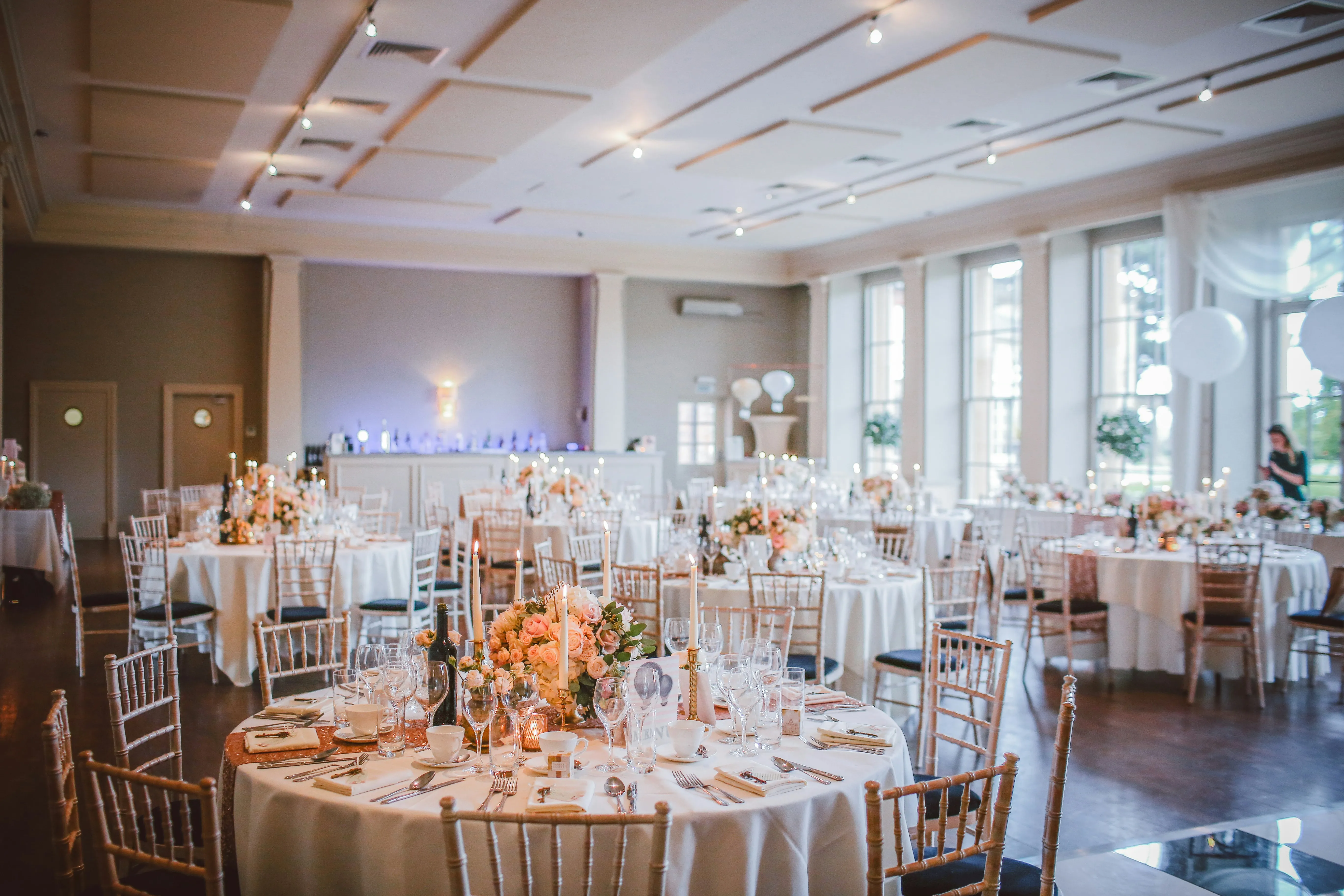 A wedding room laid and waiting for guests in evening light.